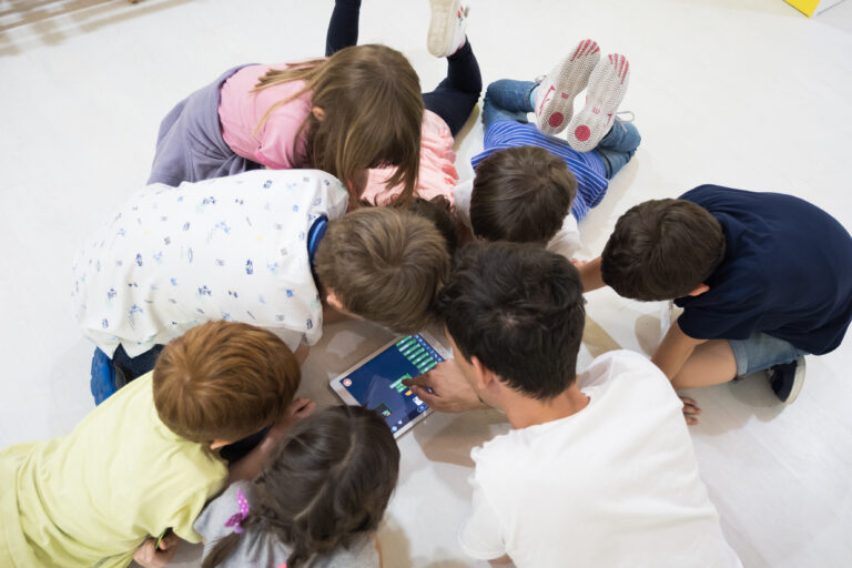 Gruppo di bambini interagisce con un supporto digitale